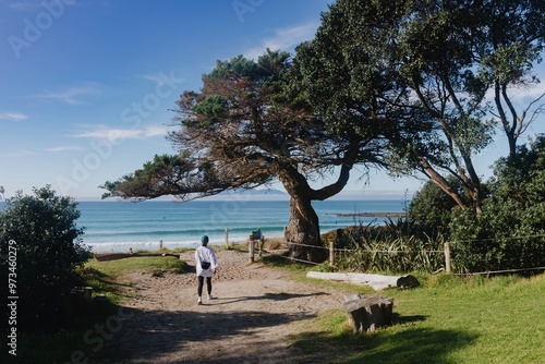 Woman walking onto the beach at Tawharanui, Warkworth, Auckland, New Zealand. photo