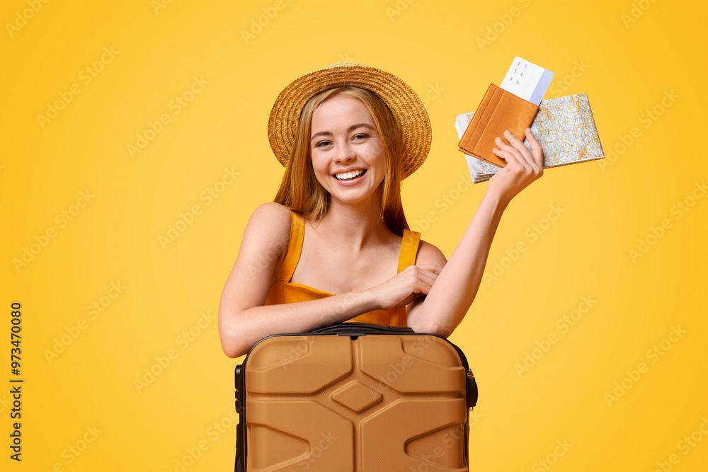 Happy girl tourist lean on suitcase and holding flight tickets and map, ready to travel, posing over yellow background with copy space Happy girl tourist lean on suitcase and holding flight tickets and map, ready to travel, posing over yellow background with copy space