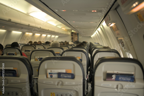 Back view of an airplane seats with few passengers. photo