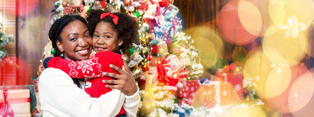 Portrait of happy black mother and little daughter posing near Christmas tree, cuddling and smiling at camera, panorama Portrait of happy black mother and little daughter posing near Christmas tree, cuddling and smiling at camera, panorama