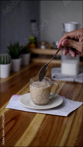 stir the coffee milk in a glass.  vertical video photo