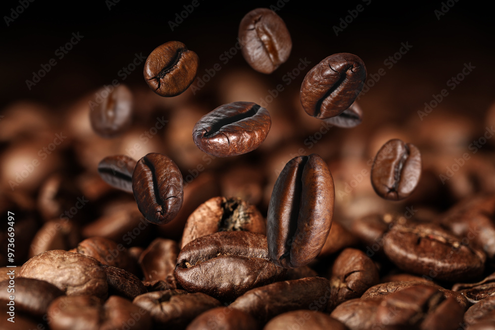 Roasted coffee beans falling on heap against black background, closeup Roasted coffee beans falling on heap against black background, closeup