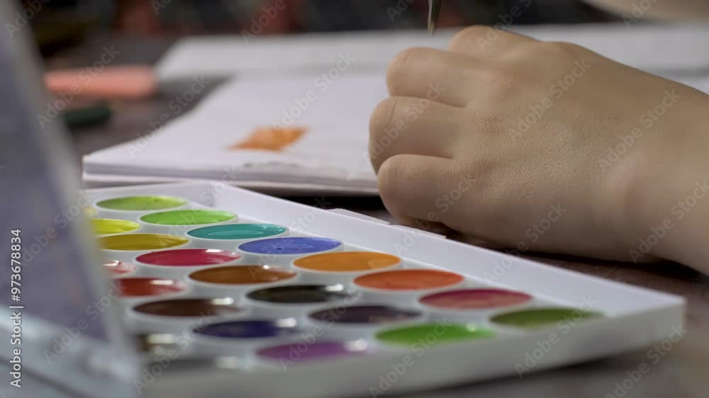 Painting with watercolors and brush at table. Art and inspiration. Workspace of creative child using colorful paint set. Leisure and hobby Painting with watercolors and brush at table. Art and inspiration. Workspace of creative child using colorful paint set. Leisure and hobby