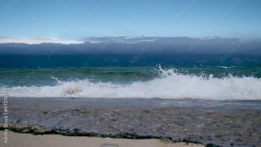 the shore of Lake Baikal with a sandy shore and small waves the shore of Lake Baikal with a sandy shore and small waves