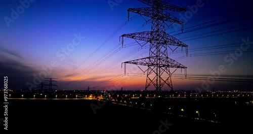 Aerial shot of high voltage electricity towers at dusk