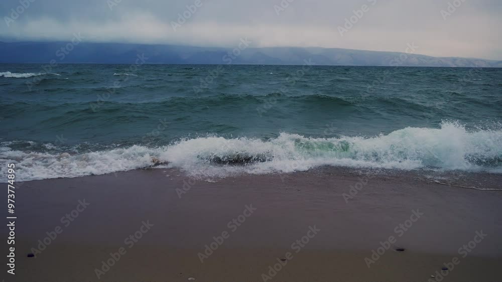 the shore of Lake Baikal with a sandy shore and small waves the shore of Lake Baikal with a sandy shore and small waves