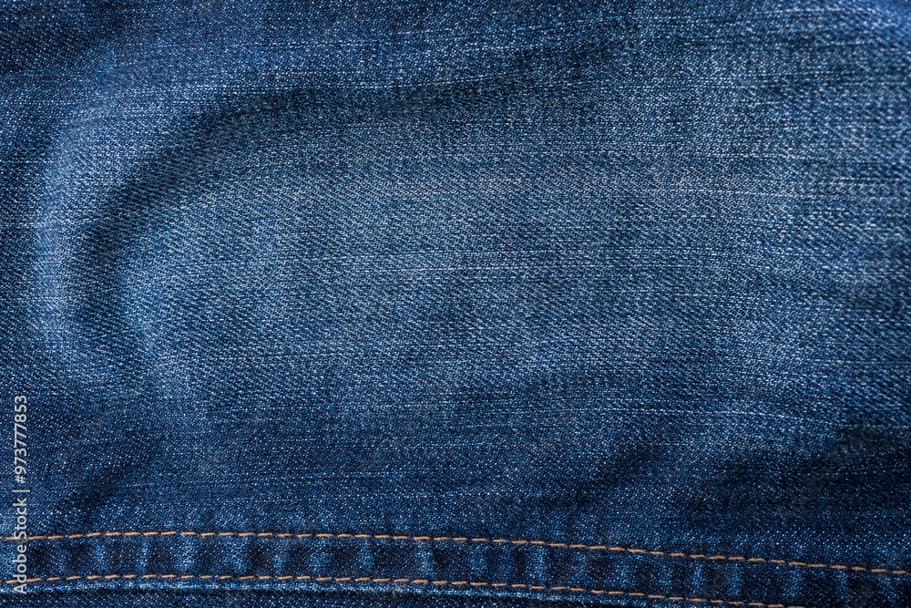An image of close-up blue denim jeans fabric showing detailed texture with a dark blue color and a stylish design backdrop