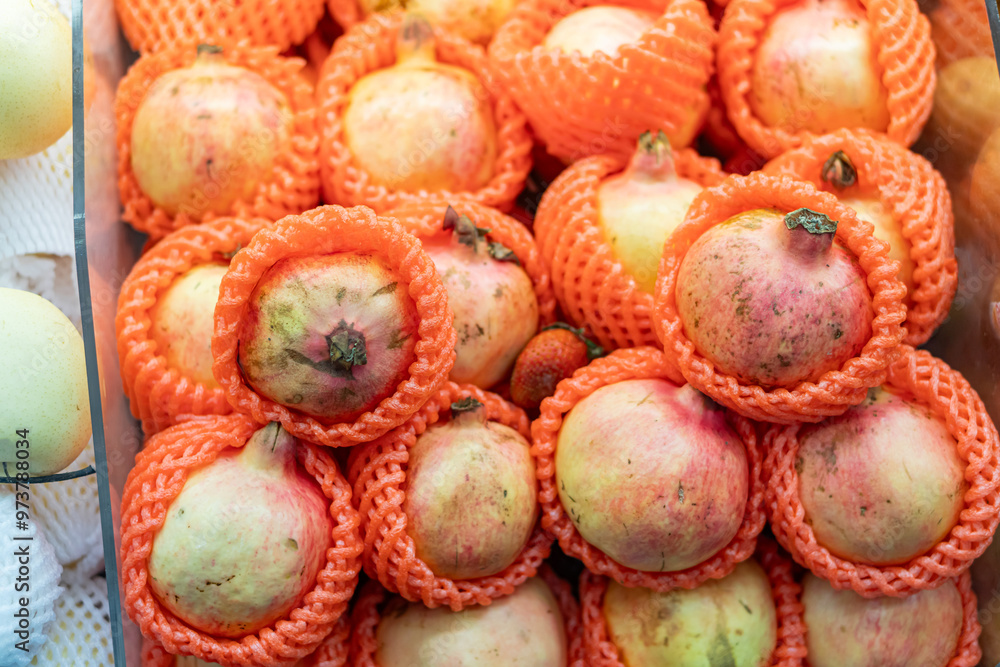 Fresh Pomegranates in Orange Netting Fresh Pomegranates in Orange Netting
