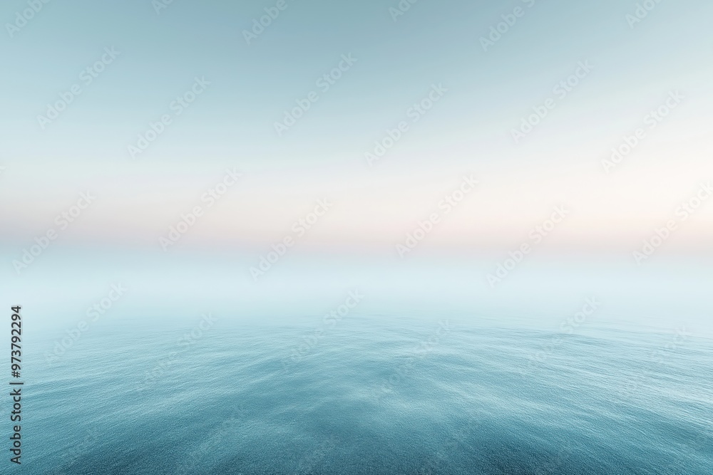 Fototapeta premium Calm ocean water merging with foggy sky at sunset