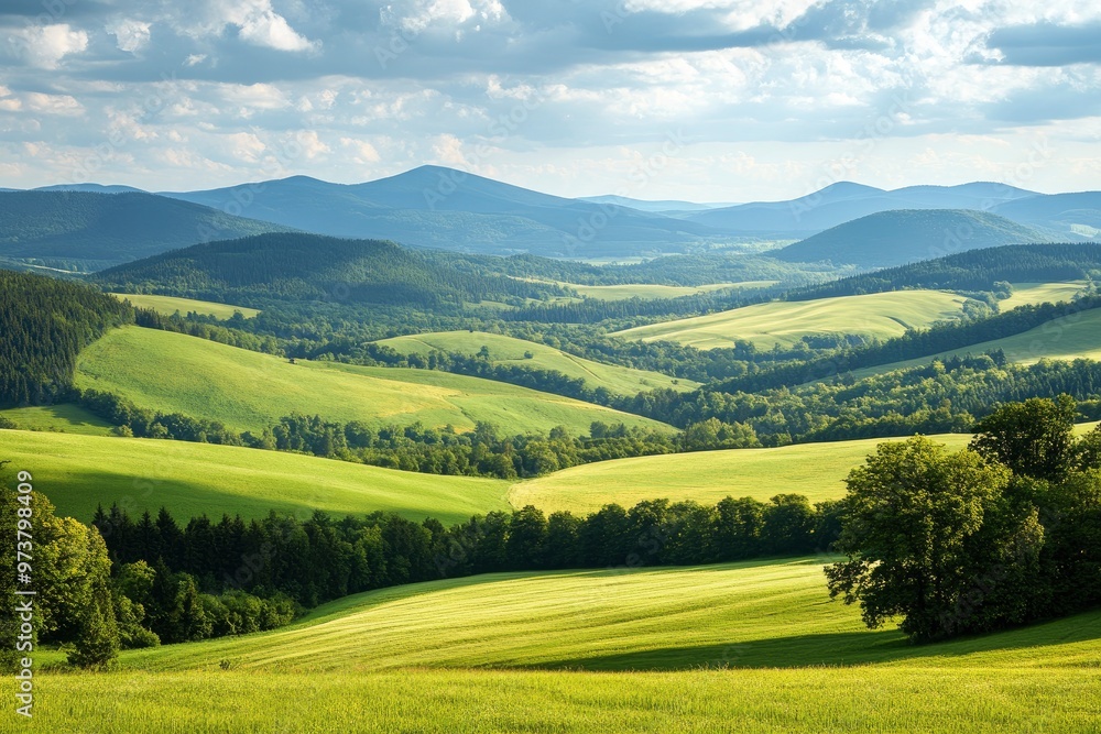 Fototapeta premium A scenic view of rolling green hills and distant mountains in the Kralicky Sneznik Mountains of Czechia. The landscape is bathed in warm sunlight, creating a serene and peaceful atmosphere , ai
