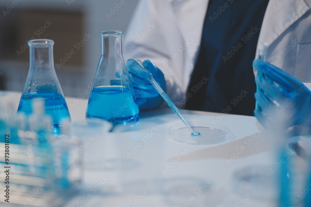 Group of dedicated scientist conduct chemical experiment in medical laboratory, carefully drop precise amount of liquid from pipette into test tube for vaccine drug or antibiotic development. Neoteric Group of dedicated scientist conduct chemical experiment in medical laboratory, carefully drop precise amount of liquid from pipette into test tube for vaccine drug or antibiotic development. Neoteric