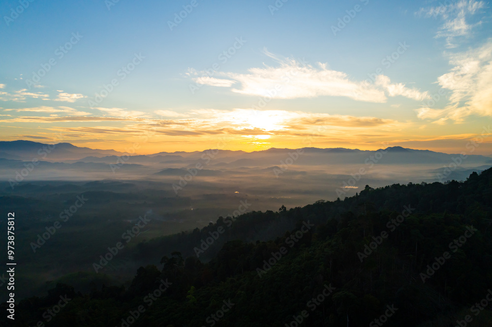 Obraz premium Amazing Sunrise or sunset over mountains hills covered with mist, Aerial view landscape drone shot beautiful colorful nature background