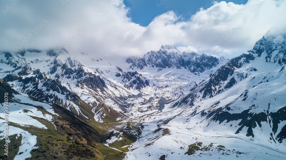 A breathtaking aerial view of a snow-covered mountain valley under a cloudy sky showcasing nature's stunning beauty. A breathtaking aerial view of a snow-covered mountain valley under a cloudy sky showcasing nature's stunning beauty.