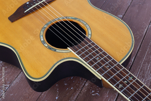 Musical instrument - Closeup fragment cutaway acoustic guitar wood background photo