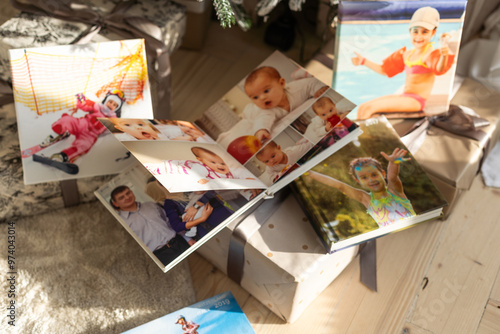 Photo book album under the Christmas tree surrounded by Christmas gifts