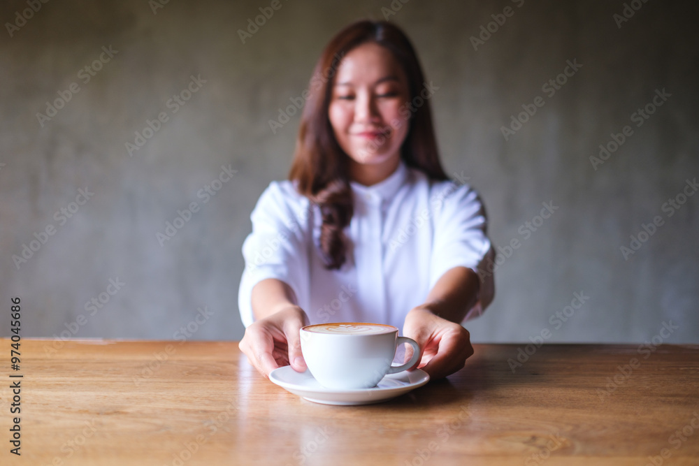 Portrait image of a woman holding and serving a cup of hot coffee Portrait image of a woman holding and serving a cup of hot coffee