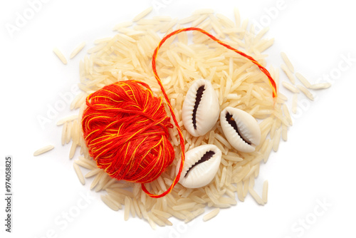 A pile of rice with kalawa (pooja thread) and Cowrie (Cypraea chinensis). Isolated on a white background. photo