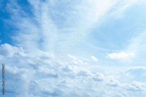 Fluffy white clouds drift across a clear blue sky, painting a beautiful summer day