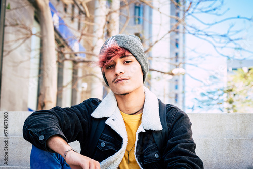 Photos Portrait of a rebellious and handsome teenage boy staring directly into the camera with a defiant and arrogant expression