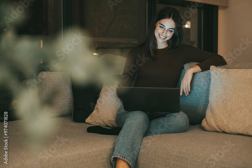 Cuadro en lienzo Young woman using a laptop in the living room at night, struggling with insomnia