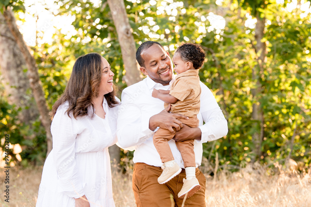 Parents laughing with son while holding him Parents laughing with son while holding him