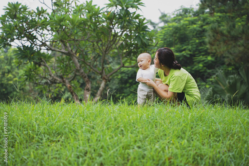 Young Asian woman playing with her son in the park