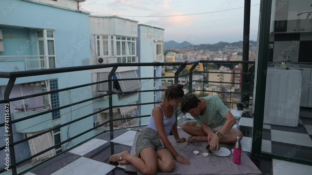 A couple enjoying a sunset dinner on their balcony, creating cherished moments together A couple enjoying a sunset dinner on their balcony, creating cherished moments together