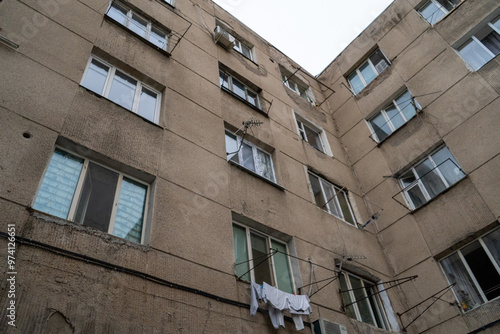 Wallpaper Mural A dilapidated Soviet-era apartment building in Bishkek, Kyrgyzstan, showing signs of wear and tear with crumbling concrete and faded windows. The structure's aged appearance is a stark reminder of the Torontodigital.ca