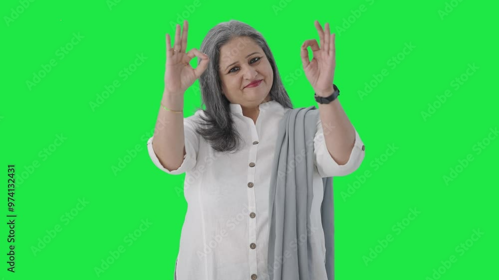 Happy Indian senior businesswoman showing okay sign Green screen Happy Indian senior businesswoman showing okay sign Green screen