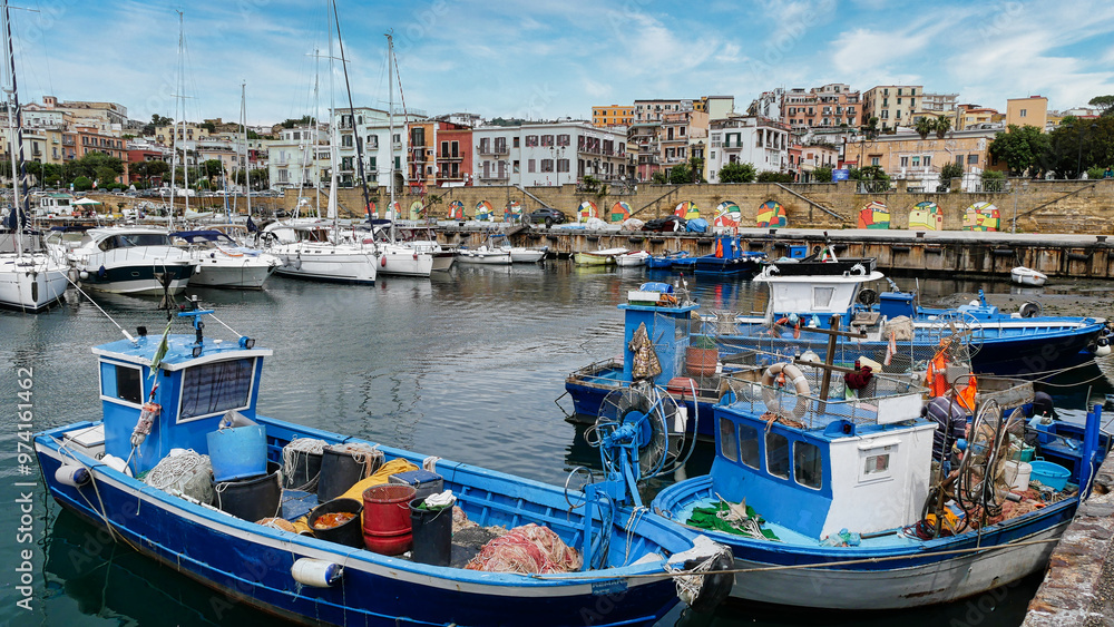 Obraz premium Diverse Boote im Hafen von Pozzuoli bei Neapel vor wunderschöner Altstadtkulisse