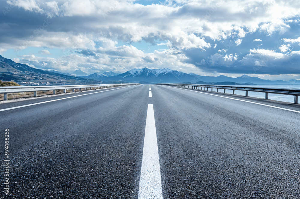 Empty asphalt highway leading to snowy mountains Empty asphalt highway leading to snowy mountains
