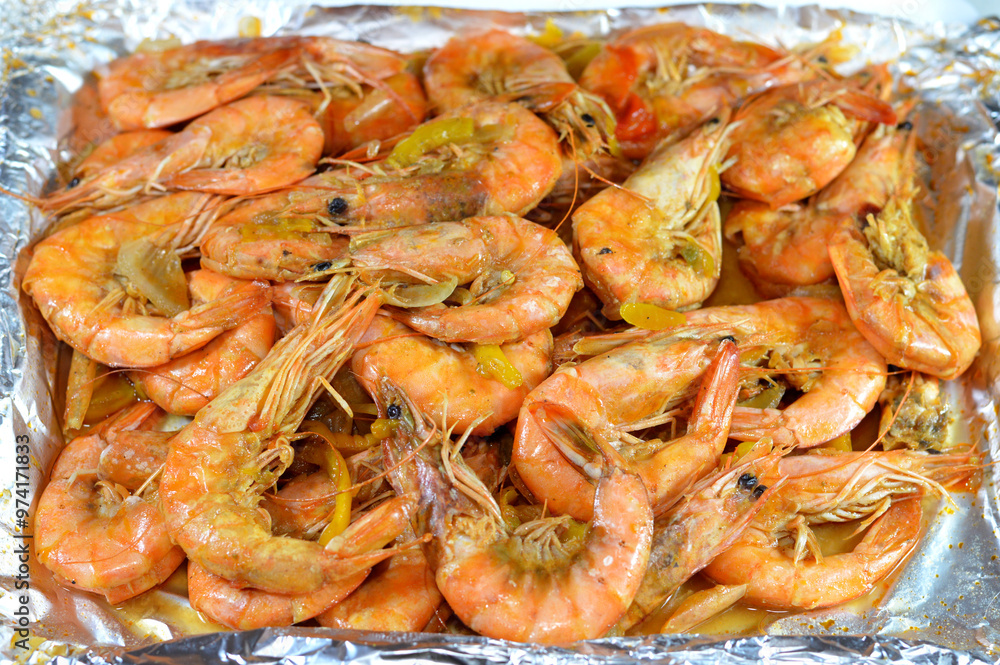 Pile of unpeeled grey shrimps cooked on hot steam and grilled with slices of onion, garlic cumin, slices of colored bell peppers and salt cooked and grilled, seafood cuisine of shrimps crustaceans Pile of unpeeled grey shrimps cooked on hot steam and grilled with slices of onion, garlic cumin, slices of colored bell peppers and salt cooked and grilled, seafood cuisine of shrimps crustaceans