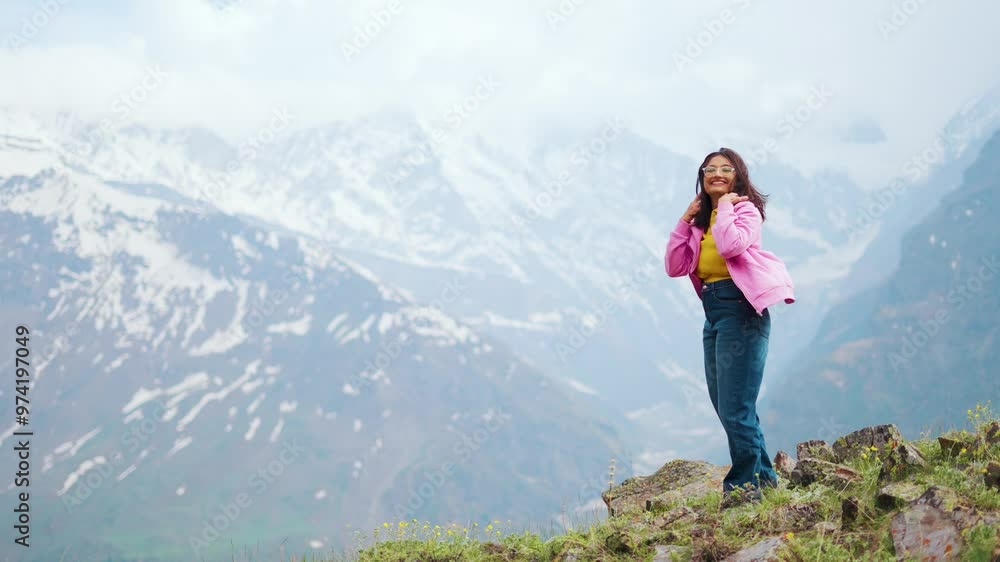 4K Portrait of young woman looking at camera while standing against snowy Himalaya mountains in Lahaul, India. Happy cheerful tourist after successful hike. Adventure, youth and travel concept. 4K Portrait of young woman looking at camera while standing against snowy Himalaya mountains in Lahaul, India. Happy cheerful tourist after successful hike. Adventure, youth and travel concept.