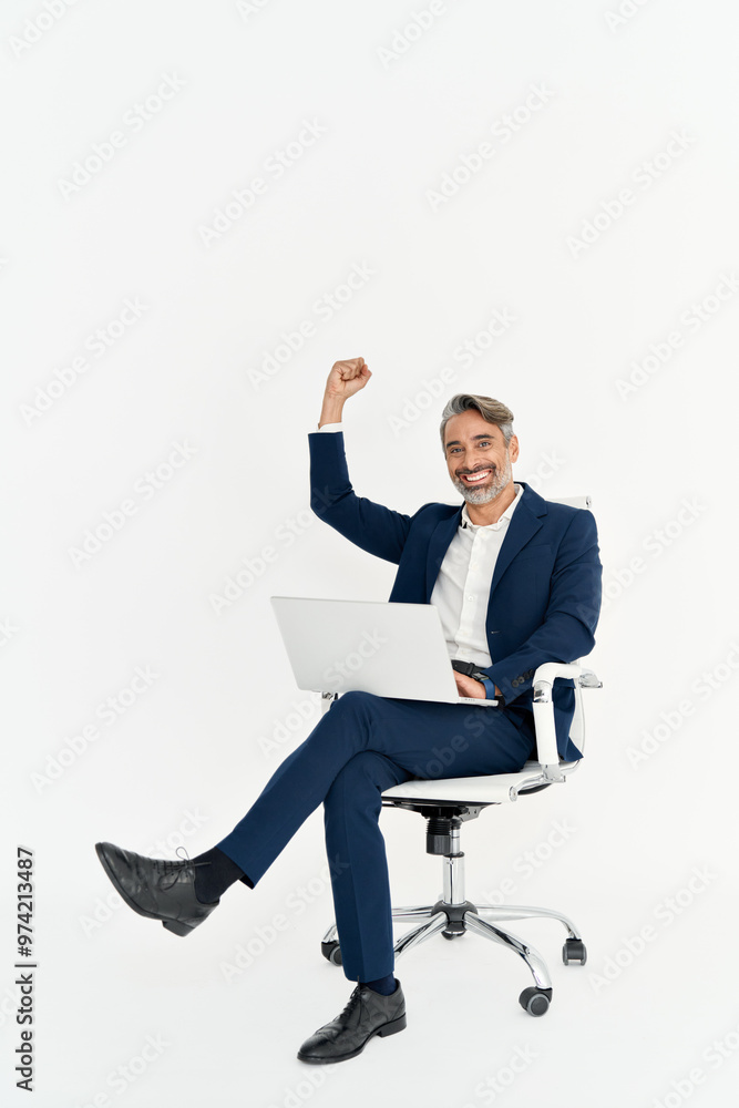 Happy mid adult business man using laptop celebrating success in office chair. Excited mature businessman winner in suit rejoicing online win, profit results isolated on white. Vertical full body. Happy mid adult business man using laptop celebrating success in office chair. Excited mature businessman winner in suit rejoicing online win, profit results isolated on white. Vertical full body.