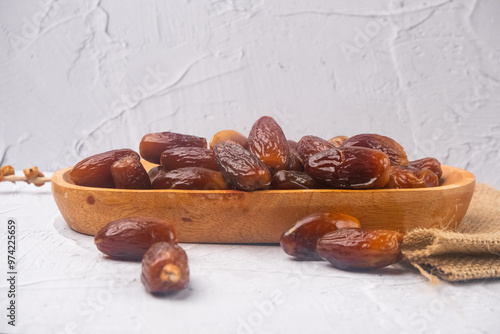 Dried date fruits in wooden bowl