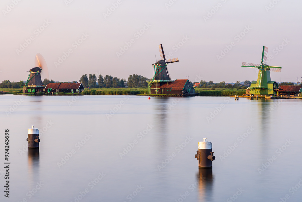 Fototapeta premium Long exposure shot of Dutch windmills along the Zaanse Schans in Zaandijk, Netherlands
