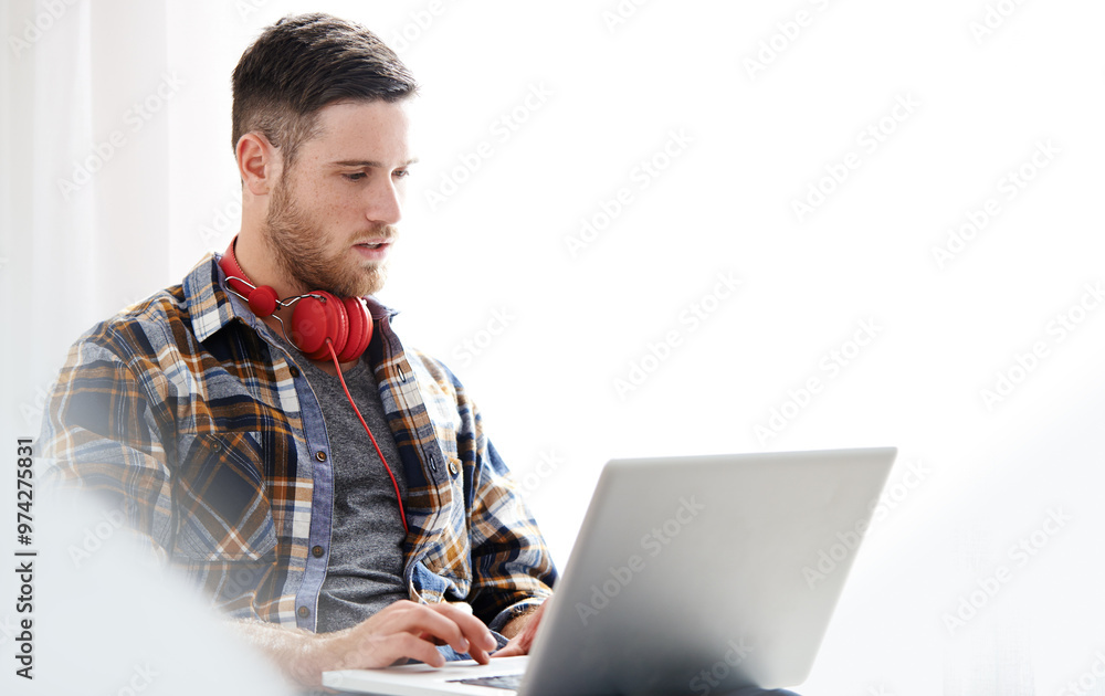 Man, headphones and typing with laptop for music software, audio or content creation at home. Young, male person or musical artist with headset on computer for digital sound track, app or podcast Man, headphones and typing with laptop for music software, audio or content creation at home. Young, male person or musical artist with headset on computer for digital sound track, app or podcast