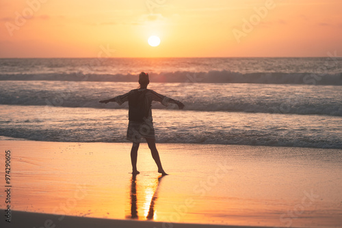 Woman enjoying sunset on sandy beach. Relax and calm on the beach.