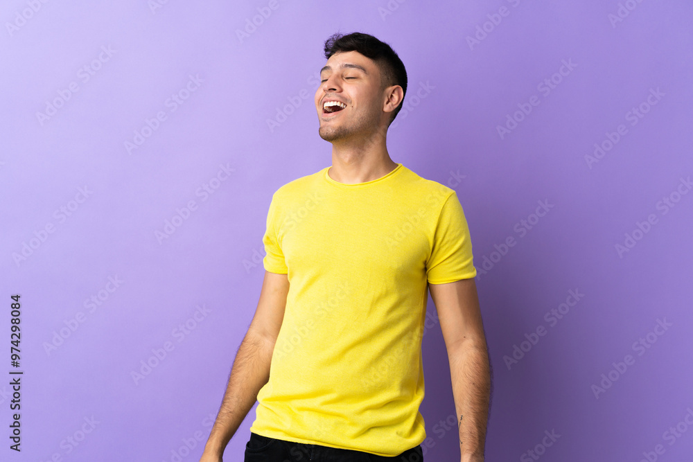 Young Colombian man isolated on purple background laughing Young Colombian man isolated on purple background laughing