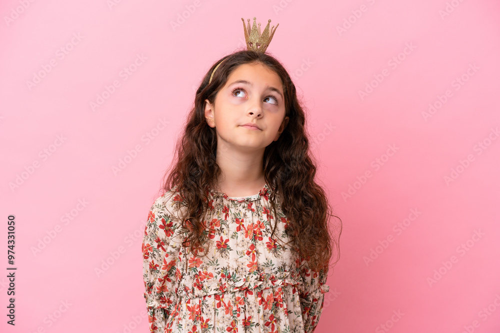 Little caucasian princess with crown isolated on pink background and looking up Little caucasian princess with crown isolated on pink background and looking up