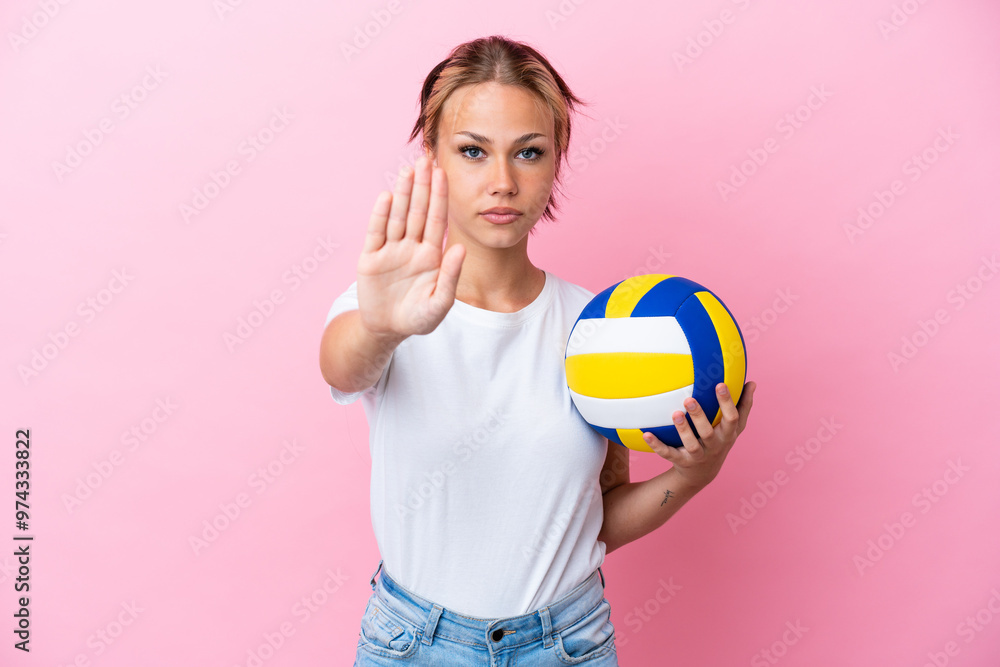 Young Russian woman playing volleyball isolated on pink background making stop gesture Young Russian woman playing volleyball isolated on pink background making stop gesture