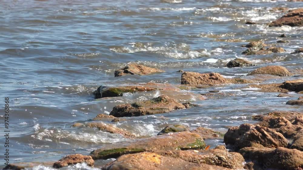 Windy weather, waves crashing on rocks and foaming in the salty hypersaline Kuyalnik estuary, Ukraine Windy weather, waves crashing on rocks and foaming in the salty hypersaline Kuyalnik estuary, Ukraine