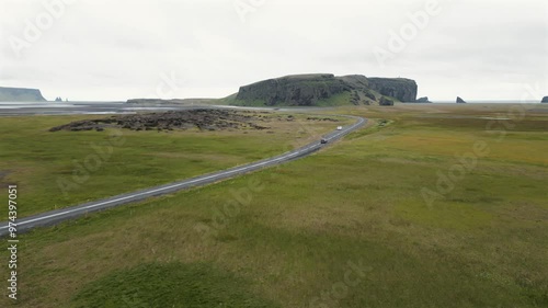 4K drone video of a road in Iceland with a car driving on it.