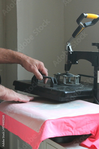 a man's hands printing a t-shirt with sublimation technique