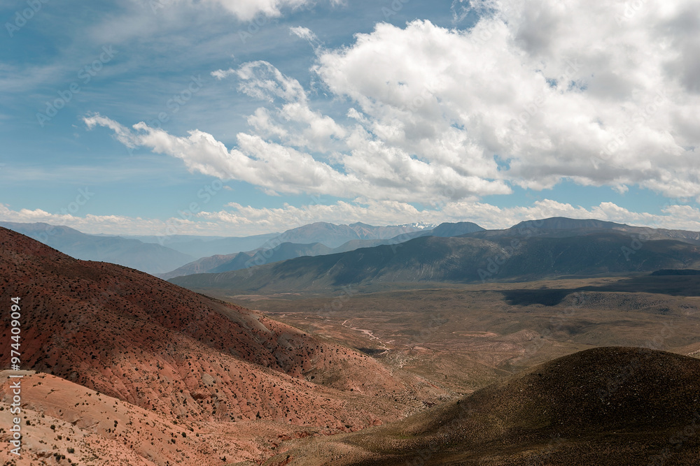 Stunning panorama of the andes mountains, painted in red and brown, under a vast sky with dramatic clouds Stunning panorama of the andes mountains, painted in red and brown, under a vast sky with dramatic clouds