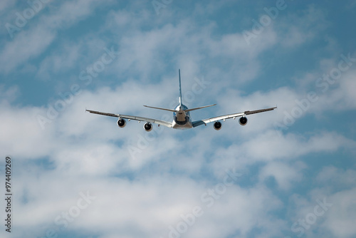 Passenger jet plane soars through a cloudy sky, symbolizing travel and freedom with a stunning backdrop of blue sky and white clouds