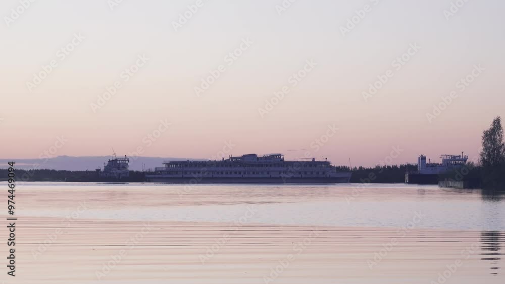 River navigation. Two tugboats pull an old passenger ship in the early morning. The Svir River as part of the White Sea-Baltic navigation route River navigation. Two tugboats pull an old passenger ship in the early morning. The Svir River as part of the White Sea-Baltic navigation route