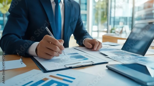 Businessman Analyzing Financial Charts and Data on Laptop