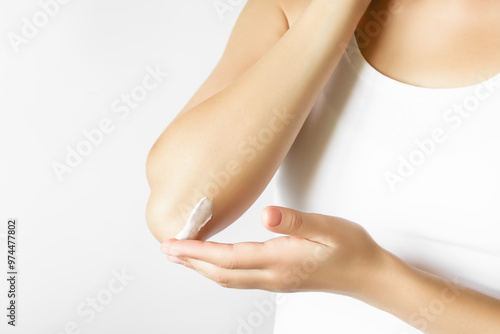 woman applying moisturizer on elbow skin, skin care concept