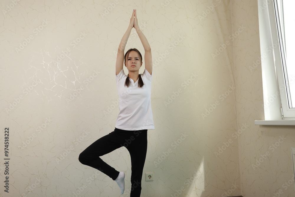 Teenage girl doing yoga at home, embracing a fit and mindful life, working on her zen and balance in a tranquil environment. Teenage girl doing yoga at home, embracing a fit and mindful life, working on her zen and balance in a tranquil environment.